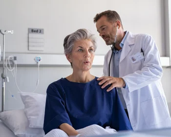 Docteur qui ausculte une dame agée