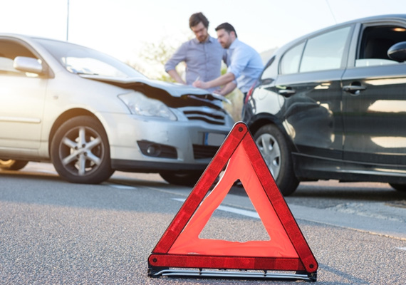 Deux hommes dessine constat sur capot voiture après un accident triangle rouge par terre sur le bitume